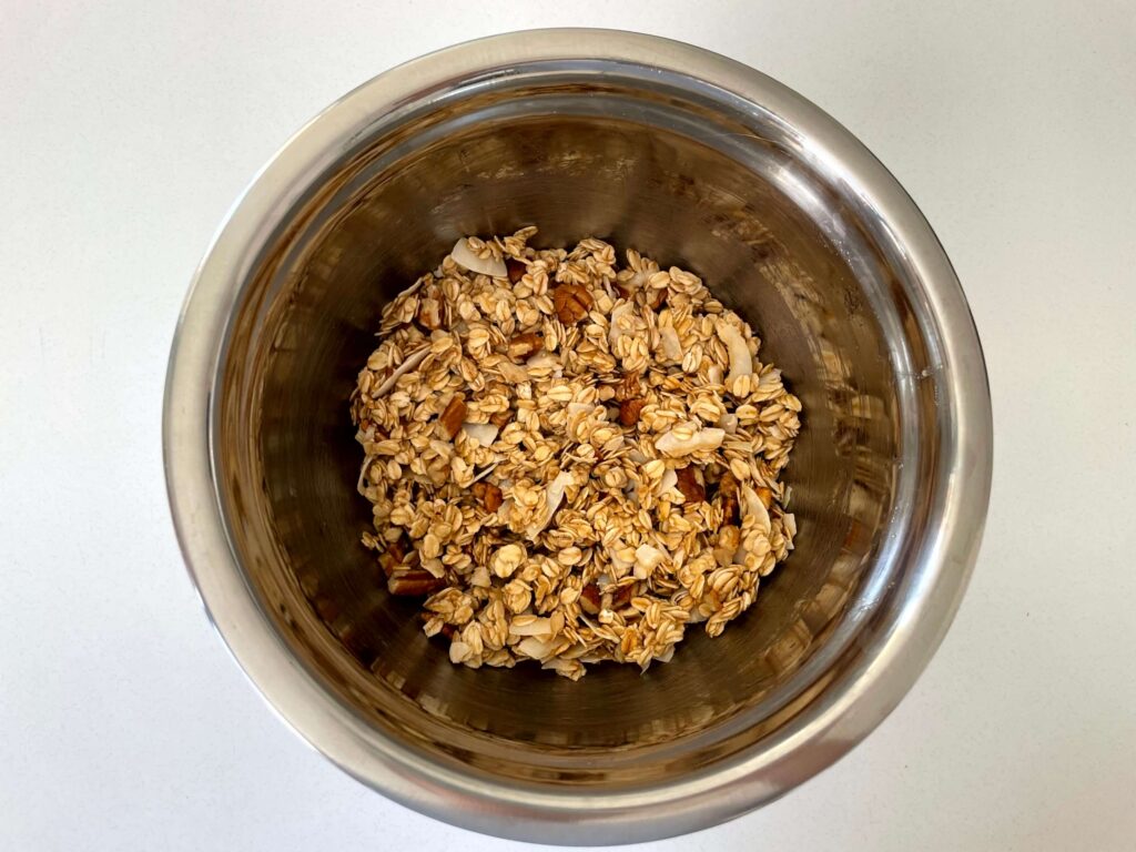 Granola ingredients mixed together in a stainless-steel bowl