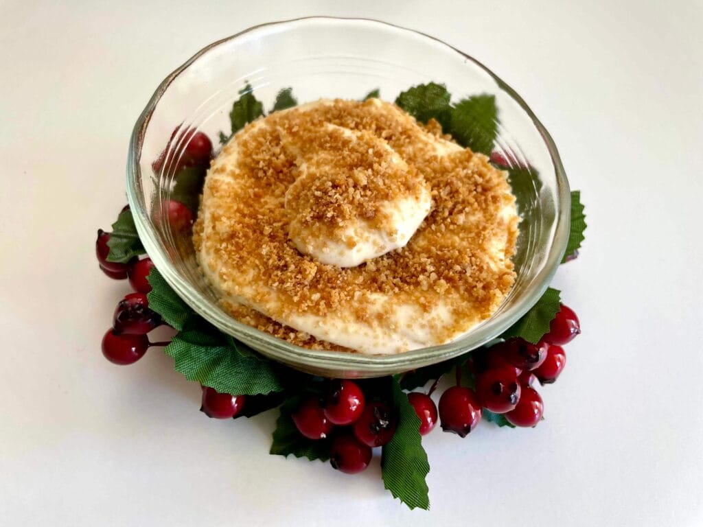 Eggnog cheesecake parfait with a Christmas holly wreath around the bowl