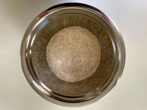 Flour, brown sugar, and desiccated coconut mixed together in a stainless-steel bowl