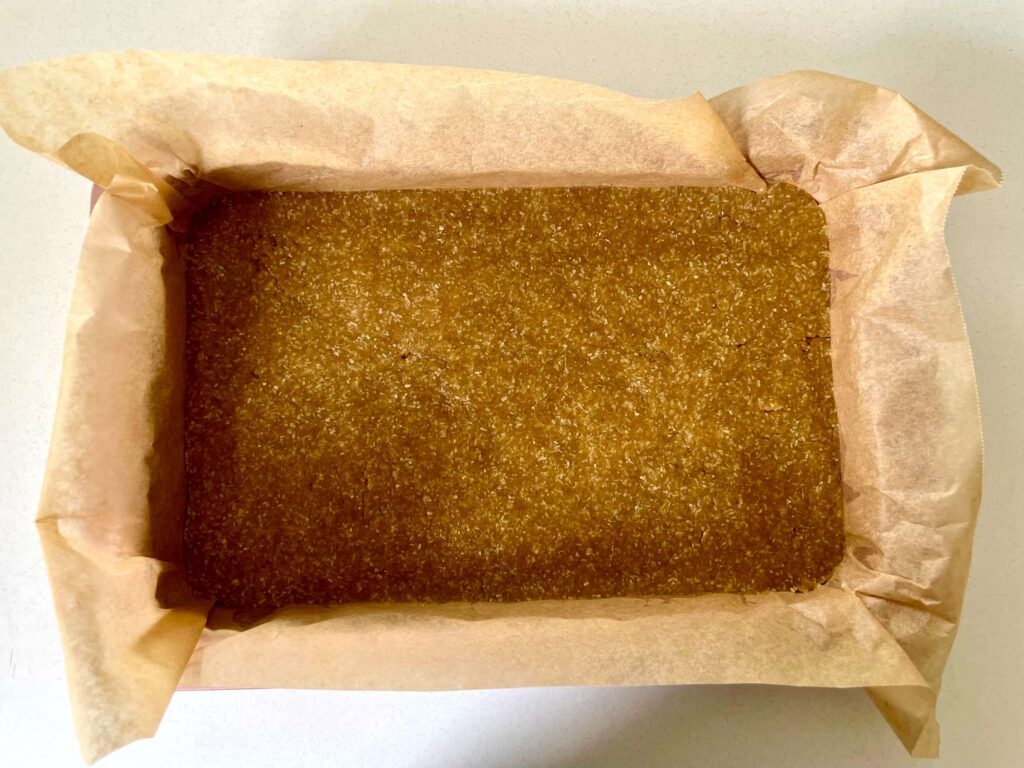 The biscuit base has been pressed into the tin and is now ready to be baked