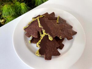 Decorated chocolate pistachio Christmas tree cookies on a plate