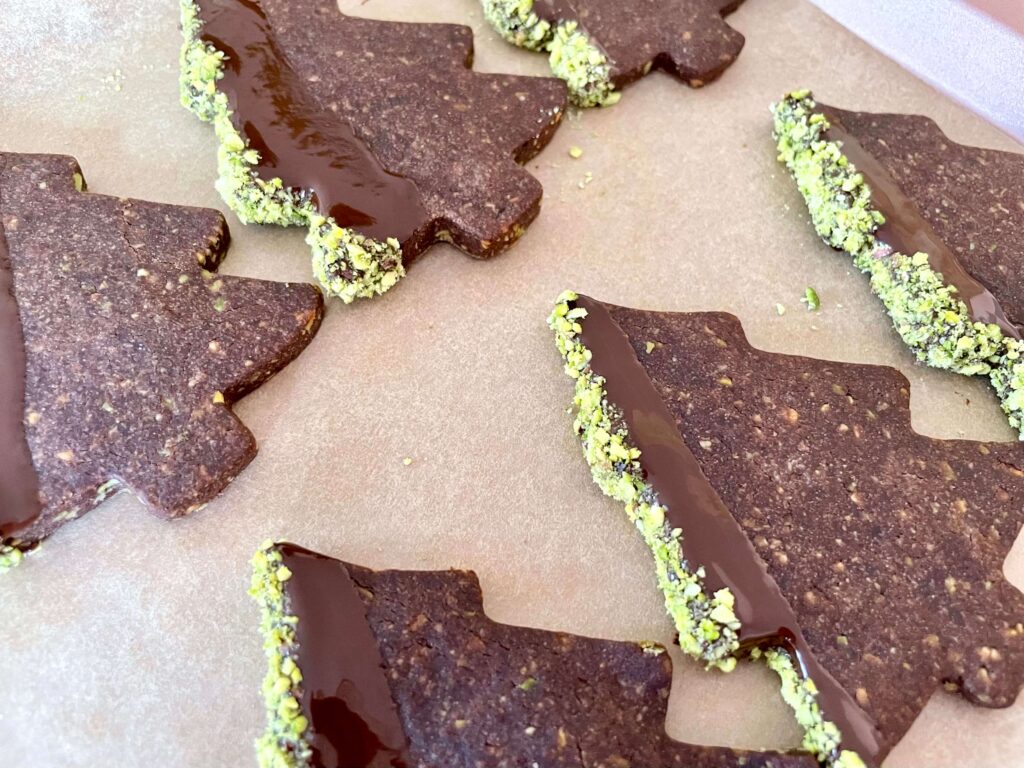 Chocolate pistachio Christmas tree cookie dipped in chocolate and pistachios