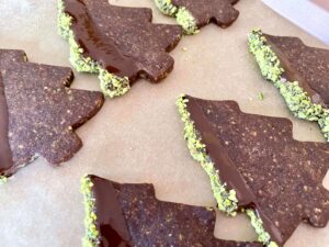 Chocolate pistachio Christmas tree cookie dipped in chocolate and pistachios