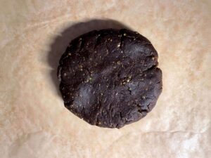 Chilled chocolate pistachio shortbread dough sitting on baking paper ready to be rolled out