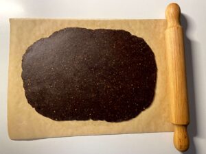 Chocolate pistachio shortbread dough that has been rolled out and is ready to cut