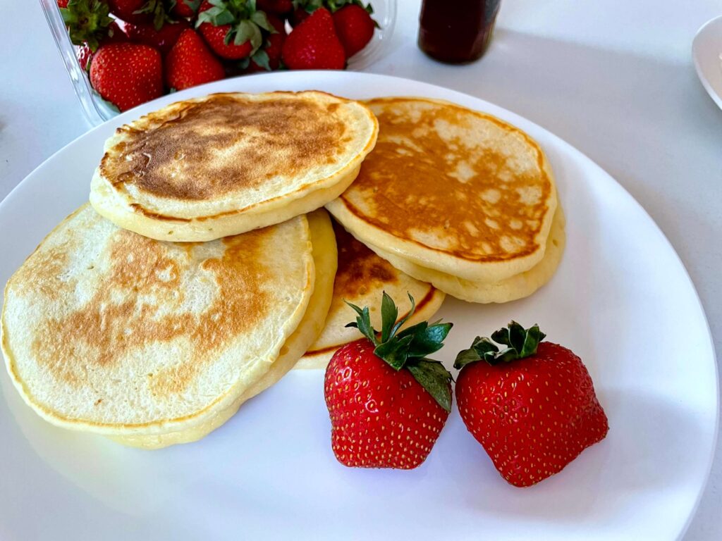 A plate of buttermilk pancakes with strawberries