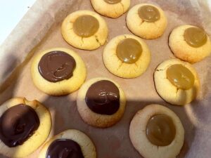 Thumbprint shortbread cookies with the centres filled with caramel and half topped with chocolate