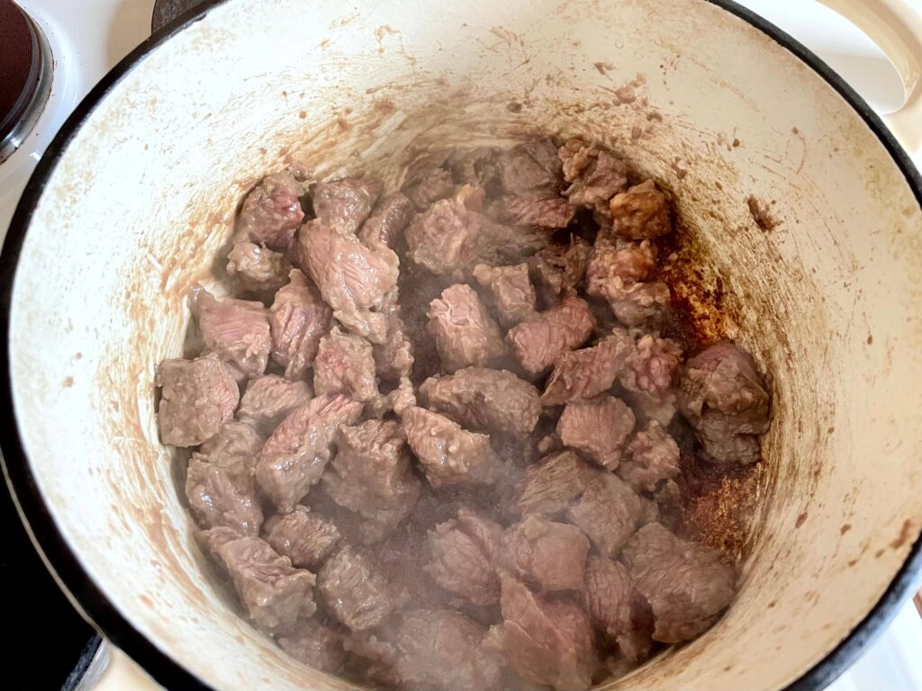 Cubed Chuck Steak Browning in a Dutch Oven on the Stove