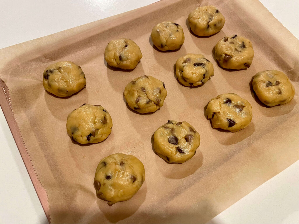Chocolate Chip Cookie Dough Rolled into Balls on a Baking Tray
