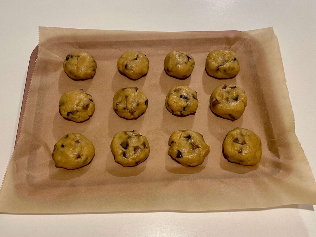 Chocolate Chip Cookie Dough Rolled into Balls on a Baking Tray