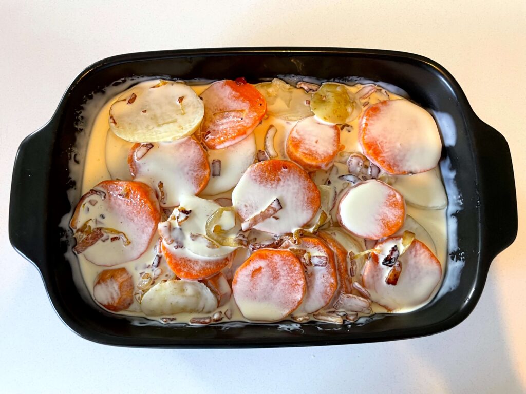 Layers of Bacon-Onion Mixture and Sliced Potatoes with Cream